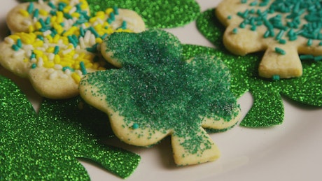 Clover shaped cookies with green decorations.