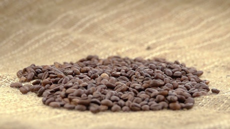 Coffee beans falling over a sack