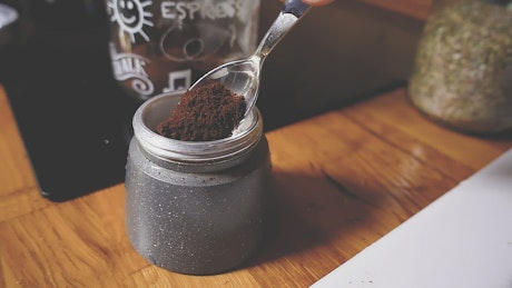 Coffee grounds being placed into a coffee puck.