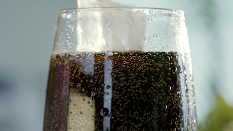 Coke foam spills from the glass