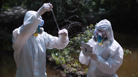 Collecting water samples in biohazard suits.
