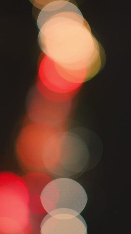 Colored lights of cars in a defocused video.