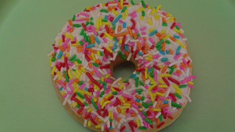 特写镜头中旋转的彩色釉面甜甜圈