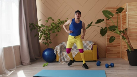 Comical man in bright clothes doing a mock workout.