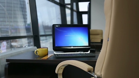 Computer and yellow cup near the window office