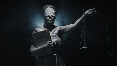 Concept of the Goddess of Justice blindfolded holding the scales.