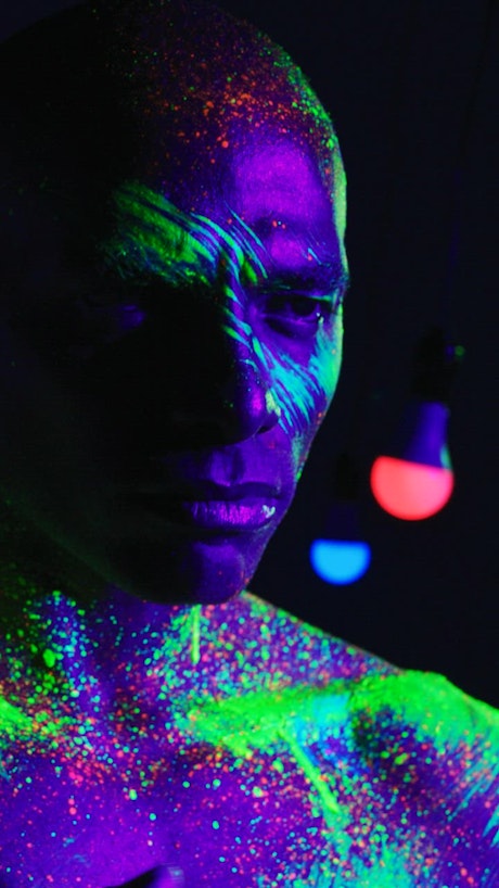 Conceptual video of a man splattered with fluorescent paint.
