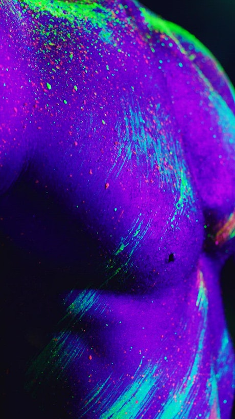 Conceptual video of a man splattered with phosphorescent paint.