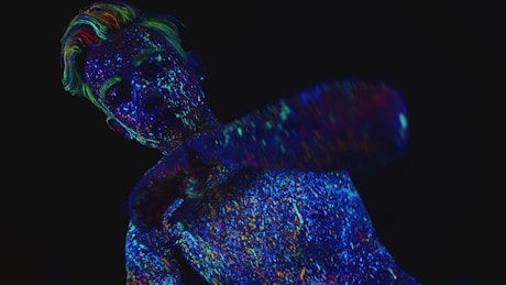 Contemporary dancer dancing in the dark in neon body paint.