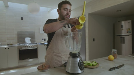 Cook adding ingredients in a blender.