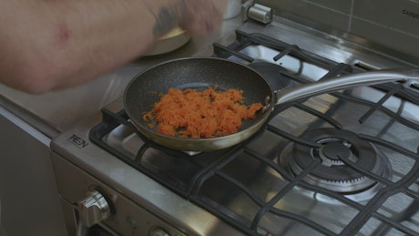 Cook preparing something in a pan