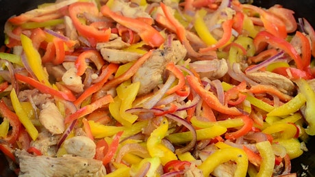 Cooking chicken and peppers.