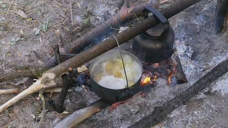 Cooking over a campfire.