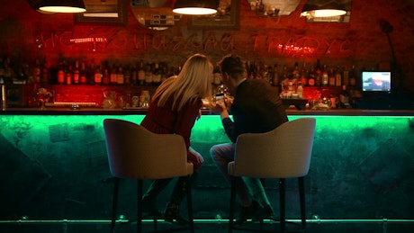 Couple checking something in a smartphone in a bar.