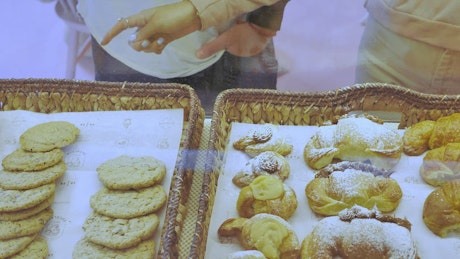 Couple choosing cookies at counter