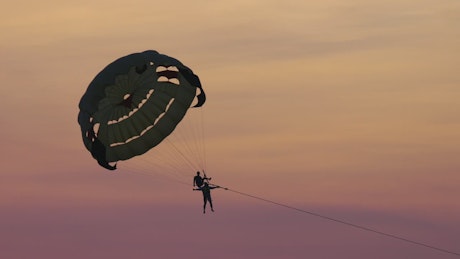 couple doing recreational parasailing in the sunset