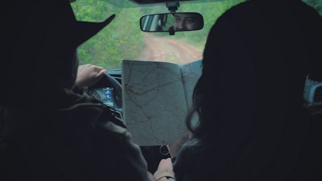 Couple following the map behind the wheel