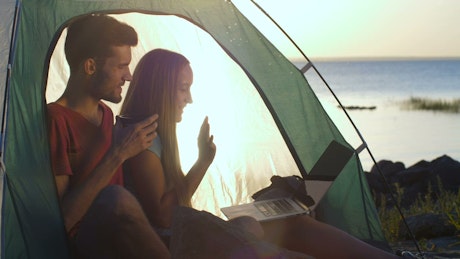 Couple having a video call while camping