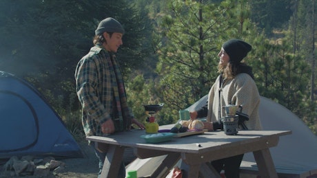 Couple having coffee in a campsite.