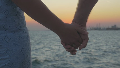 Couple holding hands during sunset