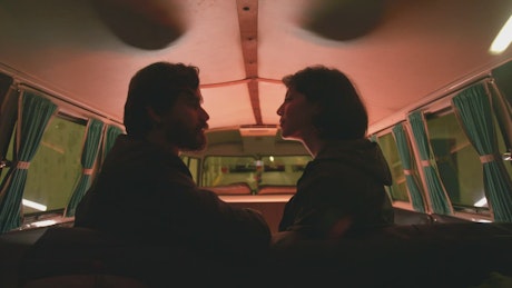 Couple kiss in a parked retro van.
