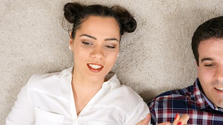 Couple lying on the carpet laughing and talking