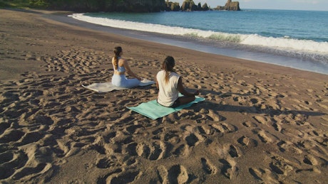 Couple meditation on a peaceful beach.