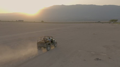 几位朋友乘坐吉普车在沙漠中进行空中拍摄