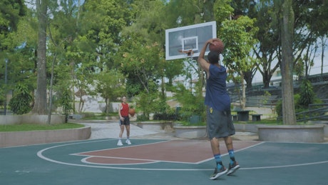 Couple playing basketball.