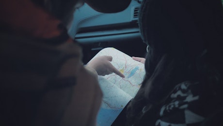 Couple reading a map inside a car