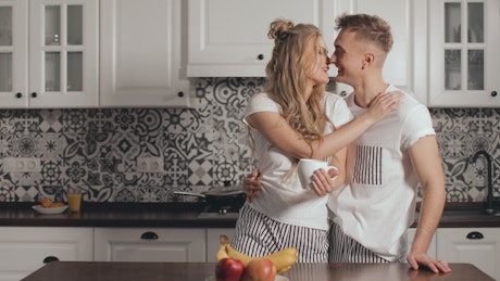 Couple share romantic moment in kitchen