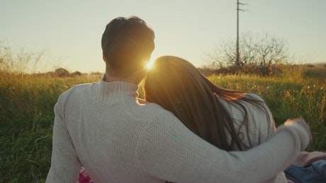Couple shares time in the countryside at sunset.