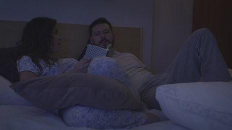 Couple talking in bed before sleeping