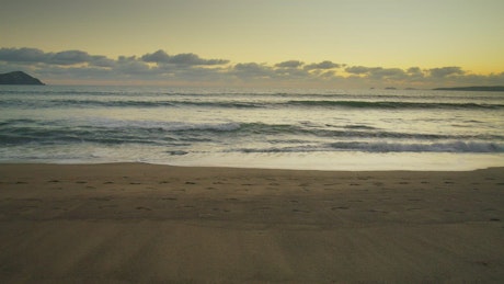 日落时分，一对情侣沿着海滩散步