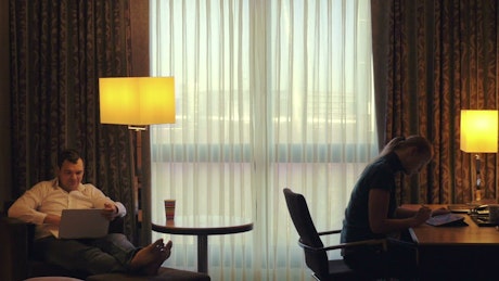 Couple working from a hotel room.