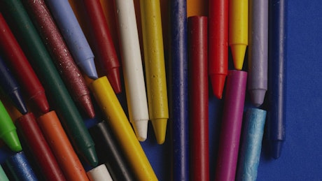 Crayons spread across colourful paper.