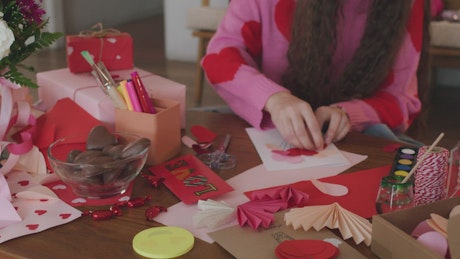 Creative girl making a decorated valentine's card.