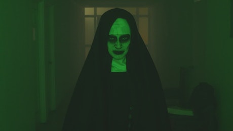 Creepy ghost nun walking looking at the camera.
