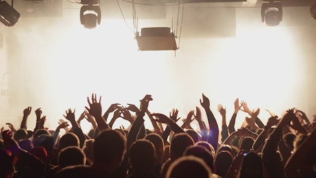 Crowd clapping in in a music concert.
