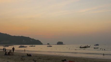 Crowded beach at dusk.