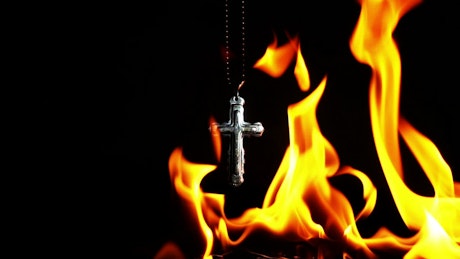 Crucifix burning on black background