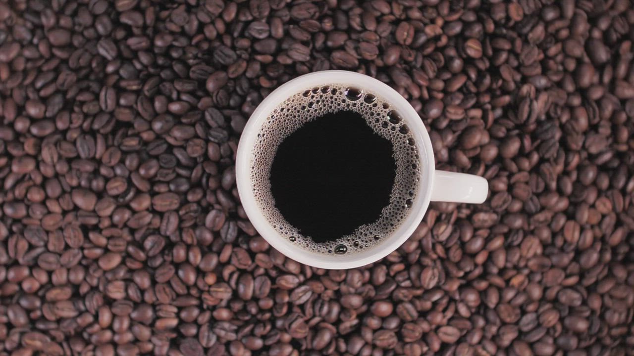 Cup of coffee on top of coffee beans Free Stock Video