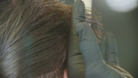 Cutting a man's hair in a close up shot.