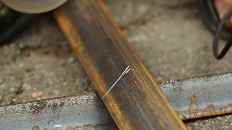 Cutting a metal bar with a saw