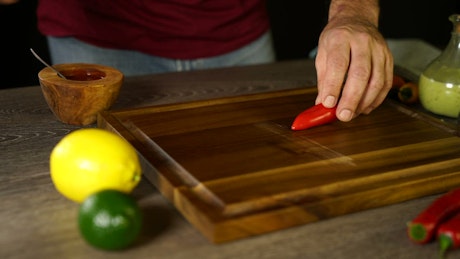 Cutting up a chilli on a board.