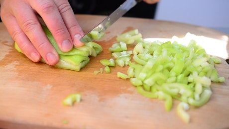 Cutting up a pepper in the kitchen.