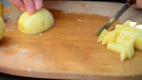 Cutting up a potato.