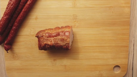 Cutting up a smoked sausage.
