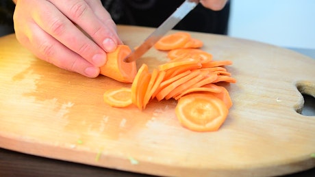 Cutting up carrots on a chopping board