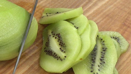 Cutting up Kiwi on a table.